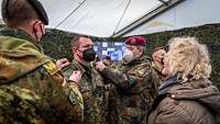 Drei Soldaten und eine Zivilistin bei der Beförderung von Soldaten.