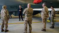 Eine Soldatin und drei Soldaten stehen mit Thomas Hitschler beim unbemannten Flugzeug NATO RQ-4D Phoenix