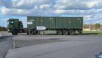 Ein LKW hat zwei Munitionscontainer geladen und steht an einer Zufahrt zu einem Bundeswehrdepot.