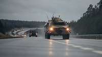 Mehrere Militärfahrzeuge fahren in Kolonne auf der Autobahn.