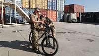 Ein Soldat und eine Soldatin prüfen etwas an einem Fahrrad