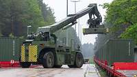 An Orion type container handler lifts a container from a Deutsche Bahn wagon