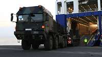 A heavy-duty transporter reverses onto a vehicle ferry.