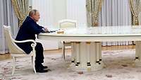 Wladimir Putin sitzt allein an einem langen Tisch