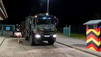 A truck driving through a barracks gate.