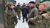 General Vollmer unterhält sich mit einem polnischen Soldaten. Im Hintergrund stehen Pressevertreter.