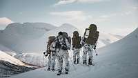 Soldaten mit Rucksäcken und Waffen laufen auf Skiern durch eine verschneite Landschaft.