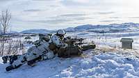 Soldaten liegen mit Gewehren im Anschlag im Schnee. 