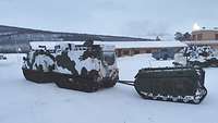 Ein Gefechtsfahrzeug der Gebirgsjäger zieht ein unbemanntes Fahrzeug über den Schnee.