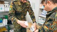 Im Lager für Sanitätsmaterial der Sanitätskompanie packen zwei Soldaten Medikamente in einen Karton 
