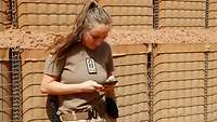 Eine Soldatin schreibt eine Nachricht auf ihrem Handy