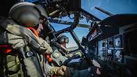 Zwei SOldaten sitzen in einem Cockpit des Marinehubschraubers Sea Lynx