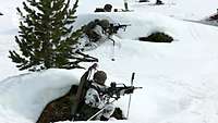 Drei Soldaten liegen in einer schneebedeckten Landschaft in Stellung jeweils mit einem Gewehr.