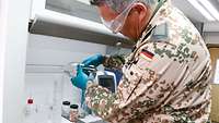 Ein Soldat schüttet den Kraftstoff im Labor in einen Standzylinder.
