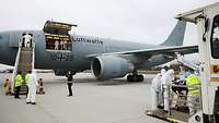 An Airbus A310 stands on the tarmac and receives patients