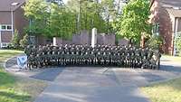 Gruppenfoto: Zahlreiche Soldaten stehen und hocken in drei Reihen in einem Halbkreis.