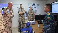 Im NOC unterhält sich ein bangladeschischer Soldat mit dem deutschen Kommandeur der MTF. Zwei weitere Deutsche hören zu.
