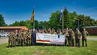 Gruppenfoto vieler Soldatinnen und Soldaten auf einer Wiese