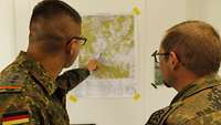 Zwei Militärpolizisten betrachten eine militärische Lagekarte