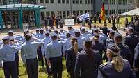 Unteroffiziere der Luftwaffe beim Grüßen, im Hintergrund ist die deutsche und israelische Flagge zu sehen.