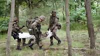 Soldaten bringen einen verletzten Kameraden aus dem Gefechtsfeld