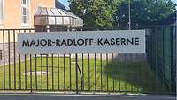 Auf dem neuen Kasernenschild steht „Major-Radloff-Kaserne“ in schwarzen Buchstaben auf weißem Grund.