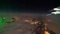 Ein Eurofighter wird in der Luft mit einem Tankschlauch von einem Airbus A400M bei Nacht betankt.