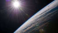 Blick auf die Erde aus dem Weltraum mit der Sonne über dem Horizont