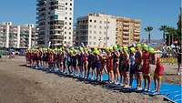 Sportlerinnen stehen in einer Reihe und warten auf den Start.