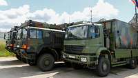 Mehrere Lastkraftwagen der Bundeswehr stehen dicht nebeneinander