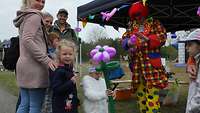 Ein Clown fertigt für Kinder Luftballonfiguren an