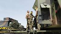 Drei Soldaten mit Gehörschutz stehen an offenen Klappen des Radargeräts