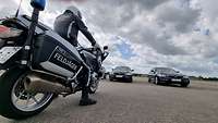 Ein Motorrad der Feldjäger steht auf einer großen Fläche vor zwei BMW-Fahrzeugen