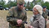 Ein Soldat mit einem Tablet und eine Zivilistin schauen beide auf den Bildschirm.