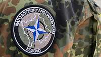 Ein Patch mit der Aufschrift „Nato Advisory and Liaison Team“ sowie „Kosovo“ auf dem Ärmel einer Uniform 