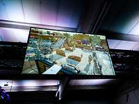 Ein Bildschirm gibt das Bild der virtuellen Realität aus, ein animierter Außenbereich mit bewaffneten Soldaten