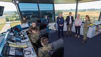 Christine Lambrecht steht mit Soldaten und weiteren Personen in dem "Tower", von dem aus die Fluglotsen alles überwachen.