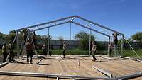 Mehrere Soldaten beim Aufbau eines Zeltes 
