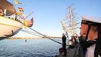 Marinesoldaten salutieren in Richtung Deutschlandflagge.