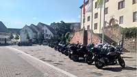 Motorräder stehen in einer Reihe vor einem Haus