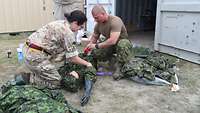 Zwei Soldaten bereiten Dummies für ein Übungsszenario vor