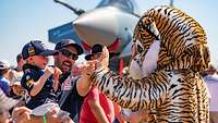 Ein als Tiger verkleideter Soldat sorgt bei einem Kind für Begeisterung