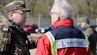 Ein Soldat unterhält sich mit einem Landrat