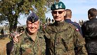 Ein Soldat der Bundeswehr und ein polnischer Soldat stehen umarmt nebeneinander