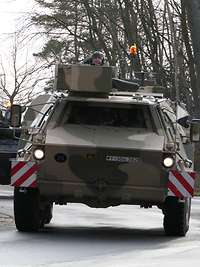 Zwei Radpanzer fahren hintereinander auf einer Straße.