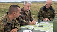 Drei Soldaten schauen auf eine Landkarte