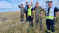 Soldaten stehen mit Feuerwehrleuten und einem Politiker auf dem Brocken im Harz.