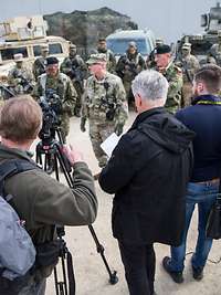 Soldaten geben Pressevertretern mit Kameras Interviews