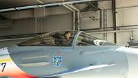 Ein Soldat sitzt im Eurofighter-Cockpit eines Kampfflugzeugs und lächelt