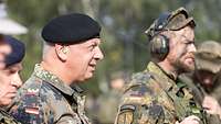 Brigadegeneral Andreas Henne und Kompaniechef Victor D. – beide mit Gehörschutz – beobachten das Gefechtsschießen.